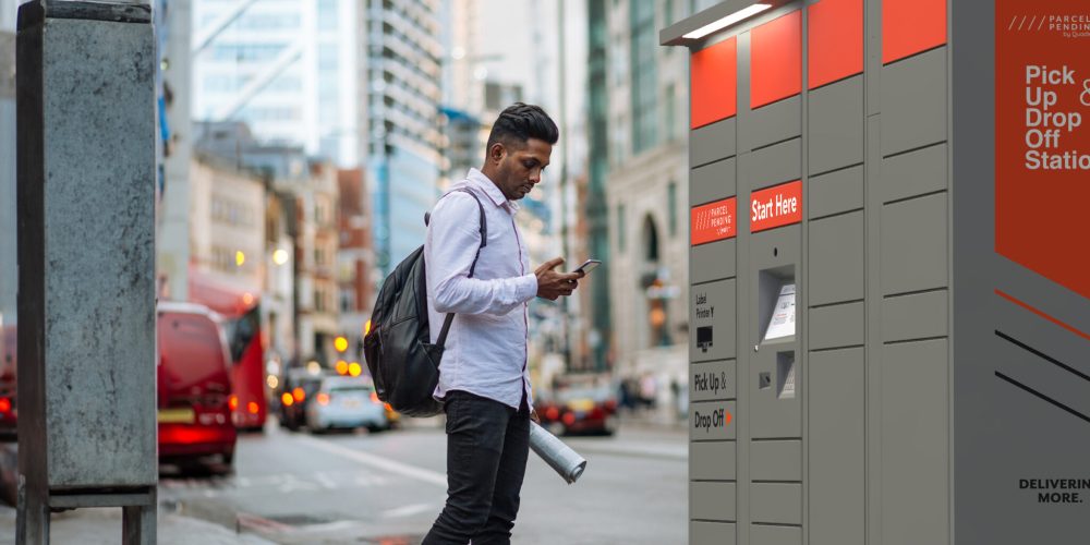 Indian young man in London, crossing the busy street while multi tasking