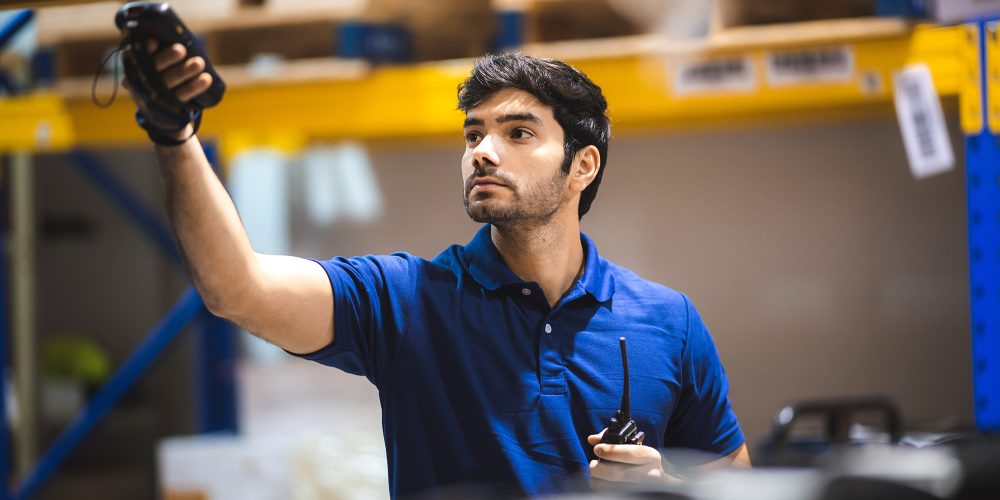 warehouse worker using bar code scanner to analyze newly arrived goods for further placement in storage department, logistic working at warehouse.