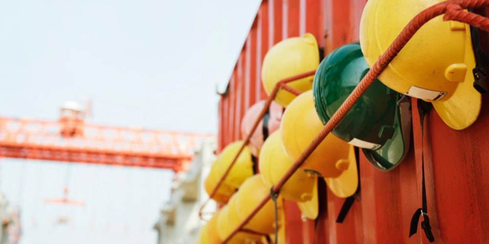 hard-hats-against-red-container